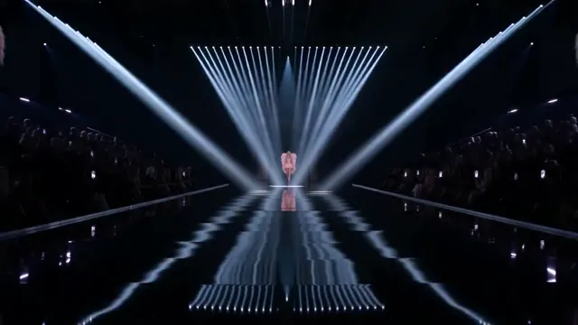 An empty AI runway lit by white light beams before the walk