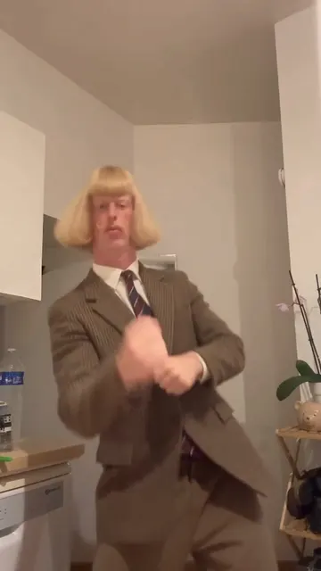 Jean Phil, the AI character with the blond bob and brown suit, shadowboxing